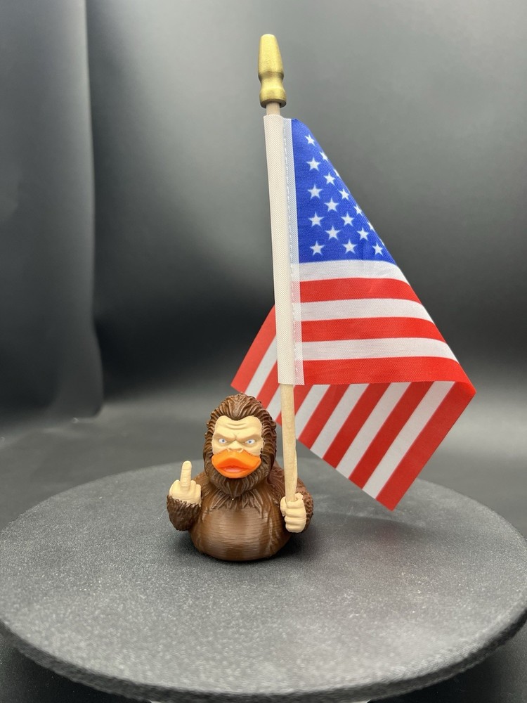 Bigfoot Ducky Figurine Guving The Middle Finger And Holding The American flag!