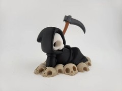 Chillin’ Grim Reaper Skeleton Figure on Skull Pile