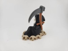 Chillin’ Grim Reaper Skeleton Figure on Skull Pile