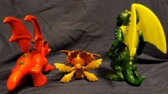 3 Cartoonish looking Dragons, large eyes, different brands