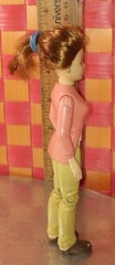 Doll, action figure, fem-character in pink top and white shirt with khaki/beige