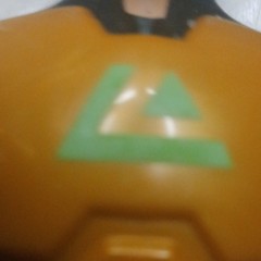 Yellow & Black Plastic Action Figure w/ Green Chest Symbol, Flesh Accents